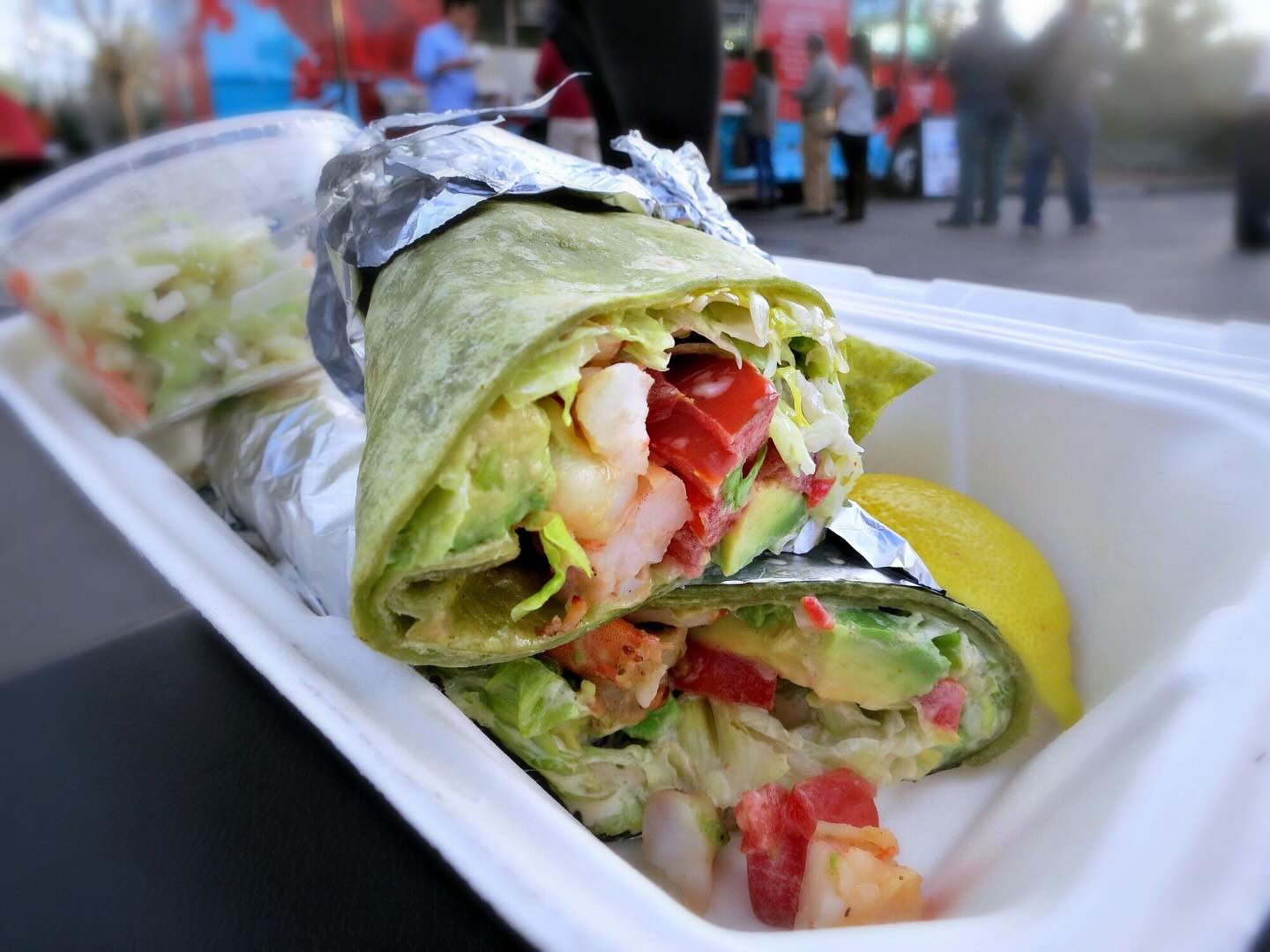 closeup of grilled prawn wrap with side of coleslaw