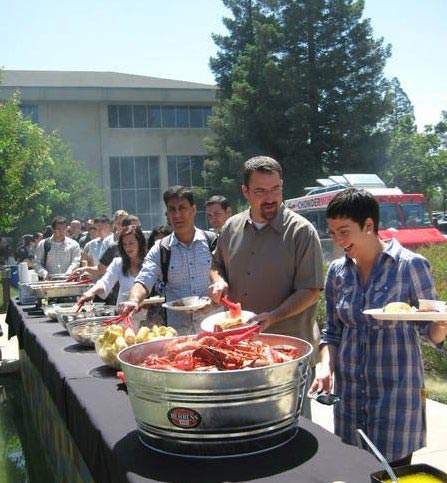 happy employees in lobster clambake buffet line at corporate on-site lunch event