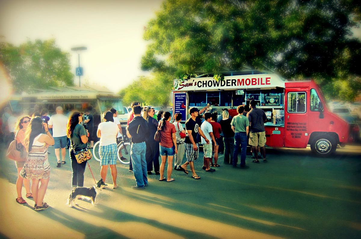line of people eagerly waiting to order seafood from Sam's ChowderMobile food truck at evening food truck event