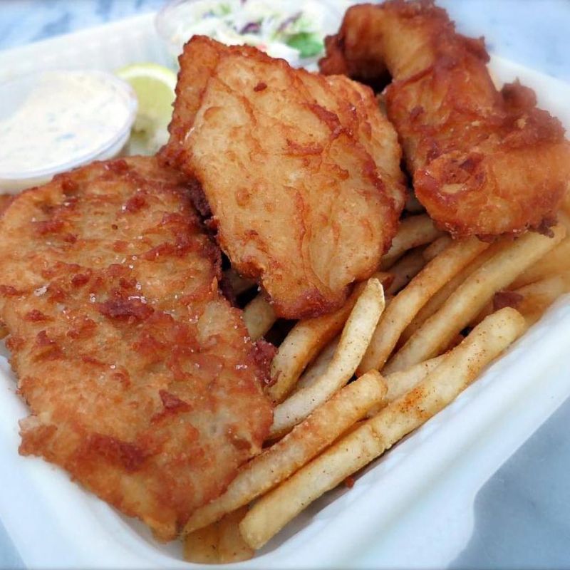 closeup of fish and chips with Old Bay french fries and coleslaw from Sam's ChowderMobile
